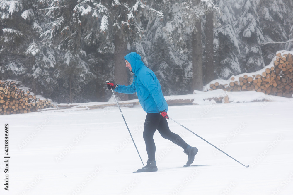 Mature man cross country skiing in forest, full length Mature man cross country skiing in forest, full length