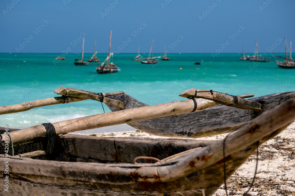 Fototapeta premium Traditional wooden dhow boats on the White Sand Beach with amazing turquoise water in the Indian ocean at Nungwi village, Zanzibar, Tanzania