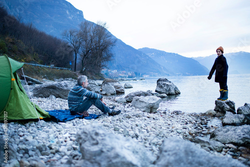 Father and son camping by lakeside, Onno, Lombardy, Italy