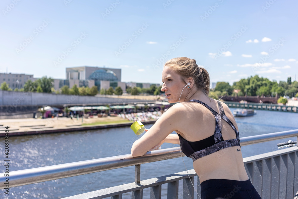 Young woman taking break from exercise in city, Berlin, Germany Young woman taking break from exercise in city, Berlin, Germany