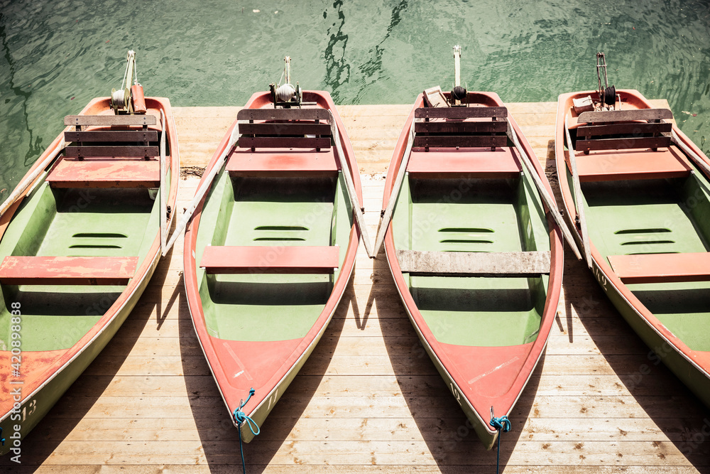 Row of rowing boats on pier at lake Tegernsee, Gmund am Tegernsee, Bavaria, Germany Row of rowing boats on pier at lake Tegernsee, Gmund am Tegernsee, Bavaria, Germany