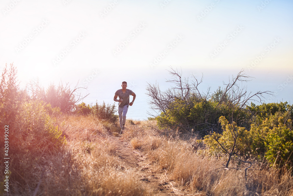 Young male runner running in Table Mountain National Park, Cape Town, Western Cape, South Africa