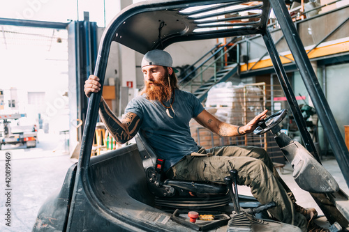 Man reversing fork lift out of warehouse