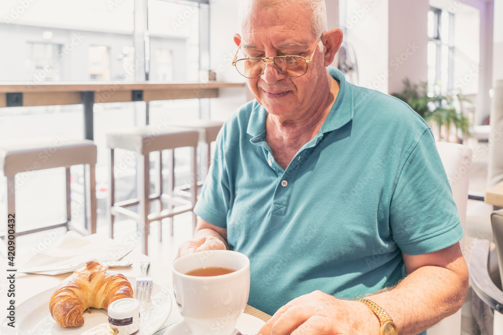 Senior man having breakfast at modern cafe Senior man having breakfast at modern cafe