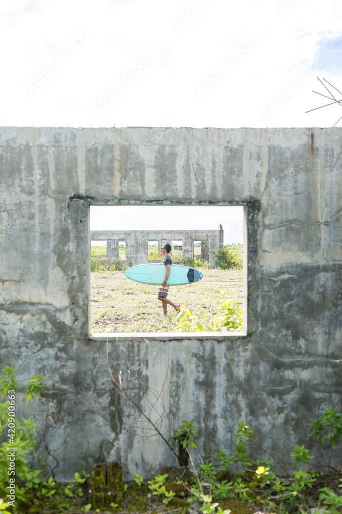 Surfer seen through window of abandoned building, Abulug, Cagayan ...