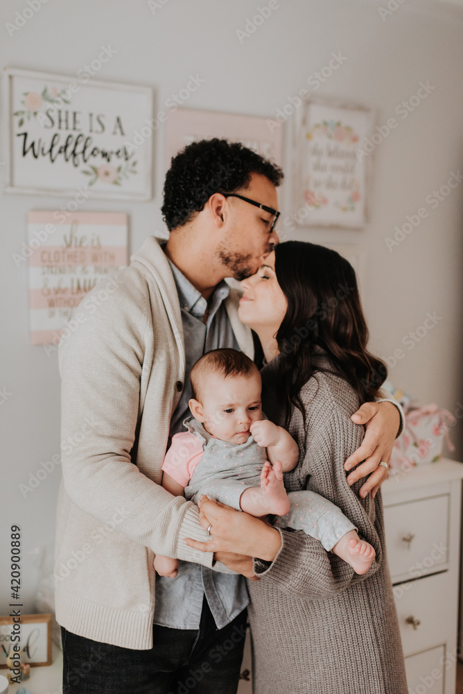 Couple with baby daughter in baby's room Couple with baby daughter in baby's room