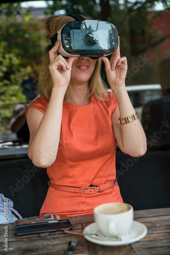 Woman using virtual reality headset in cafe photo