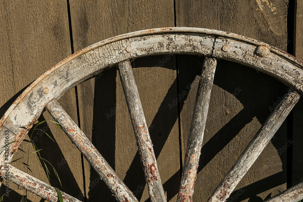 Old wagon wheel leaning against a barn, Palouse agricultural region of Eastern Washington State. Old wagon wheel leaning against a barn, Palouse agricultural region of Eastern Washington State.