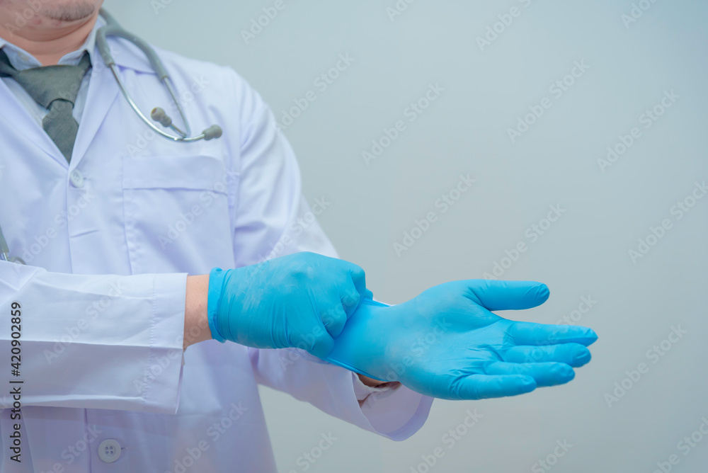 Doctor in uniform with stethoscope wearing blue gloves Doctor in uniform with stethoscope wearing blue gloves