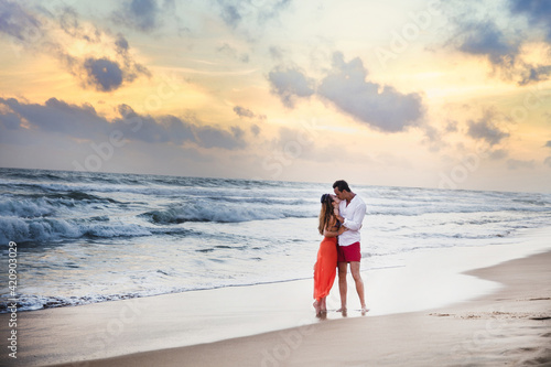 Young couple kissing on beach at sunset, Hikkaduwa, Southern, Sri Lanka photo