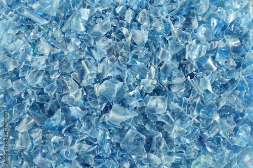 A heap of small pieces of chopped blue plastic bottles. View from above. Closeup