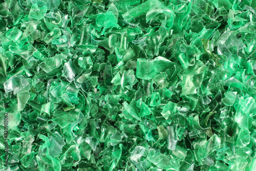 A heap of small pieces of cut green plastic bottles. View from above. Closeup