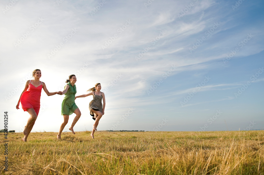 Girlfriends skipping on field, Eastbourne, East Sussex, United Kingdom Girlfriends skipping on field, Eastbourne, East Sussex, United Kingdom