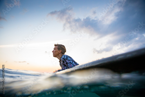 Surfer gliding in sea at sunset, Pagudpud, Ilocos Norte, Philippines photo