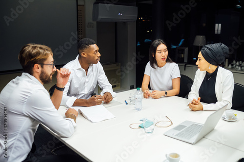 Businessmen and women having discussion during conference table meeting