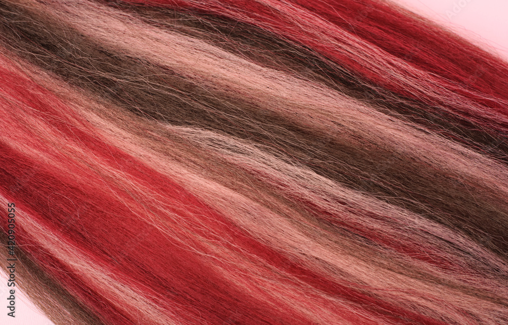 Naklejka premium Bright synthetic hair for weaving different hairstyle, braids, dreadlocks, afro braids. Pink and red Kanekalon