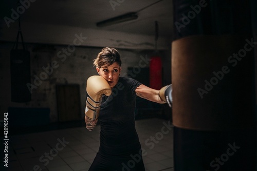 Boxer training with sandbag in gym photo