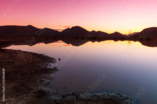 Silhouetted mountain ranges on horizon over water, Cape Town, Western Cape, South Africa