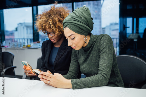 Business partners using smartphone at meeting in office