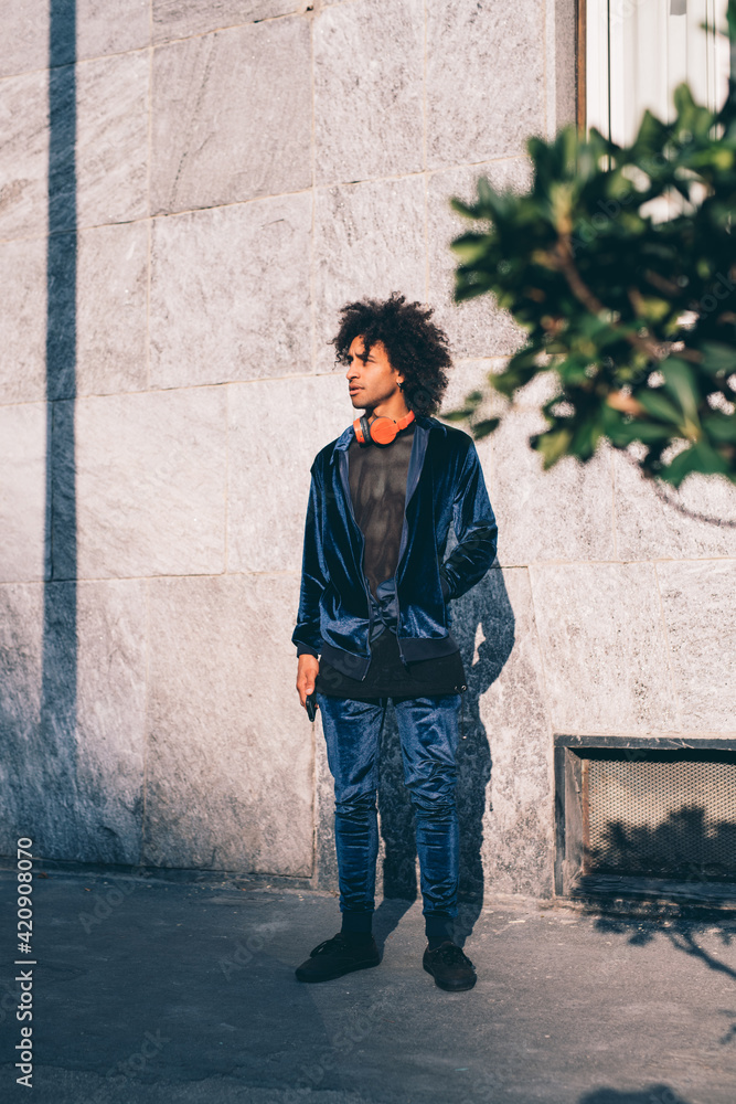 Young man waiting in front of concrete wall Young man waiting in front of concrete wall
