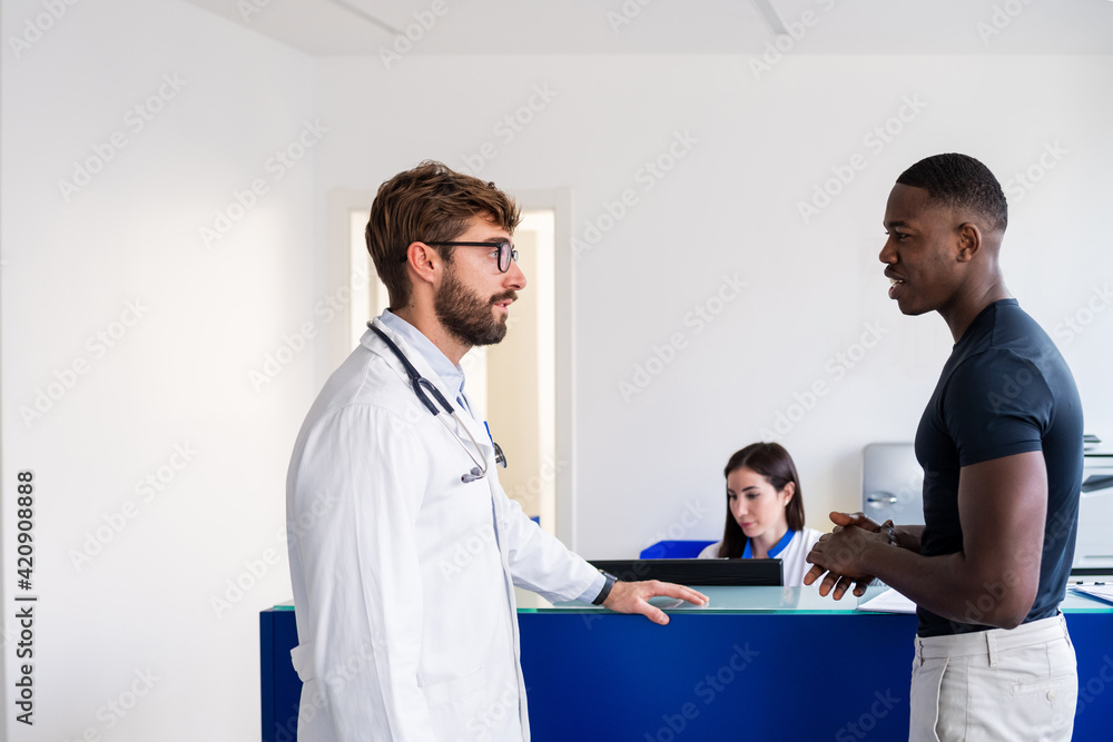 Doctor speaking with patient at hospital reception Doctor speaking with patient at hospital reception