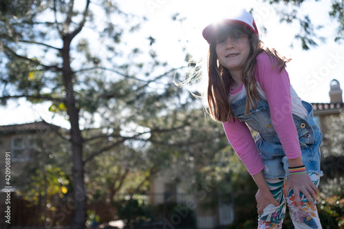 Curious girl in dungarees on sunny day