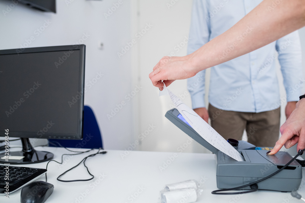 Person printing results on breathalyser machine in hospital Person printing results on breathalyser machine in hospital