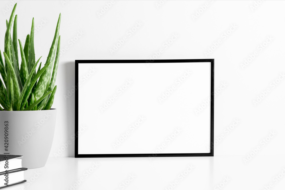 Black frame mockup with workspace accessories and aloe vera on white table. Front view. Place for text, copy space, mockup - obrazy, fototapety, plakaty 