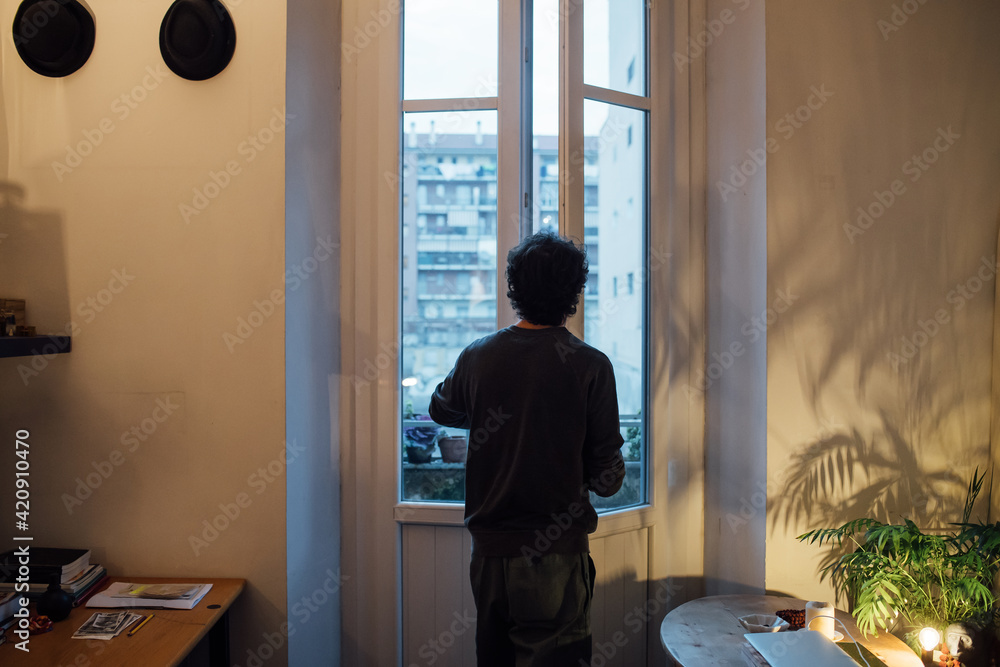 Man looking out of house window Man looking out of house window