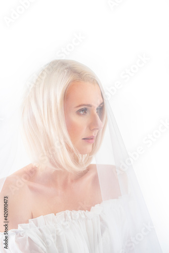 portrait of a young gentle beautiful woman bride in a veil on a white background