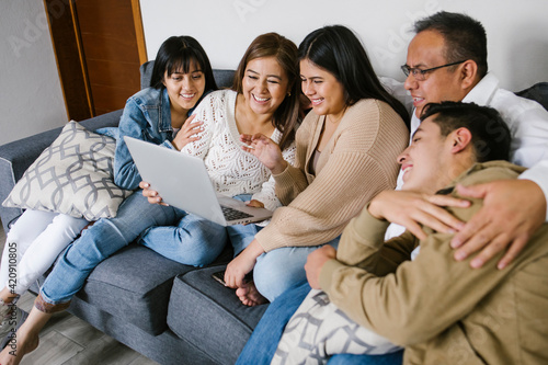 Photography hispanic family in a video conference on laptop at home in Mexico