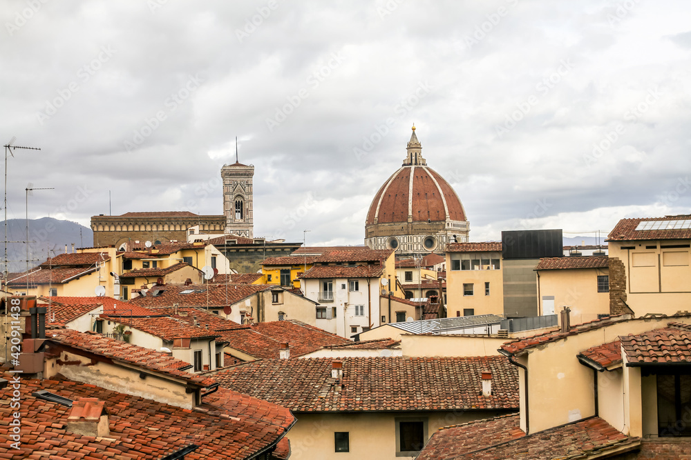 Roofs of houses and buildings with the dome in the background in Florence, Italy.