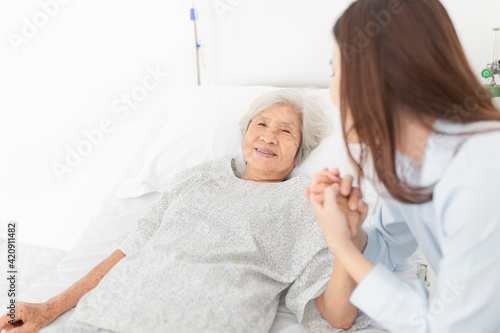 close up old people, old asian patient sick and admit in hospital, young asian female visiting old female, they holding hands together, they feeling happy and smile, elderly healthcare