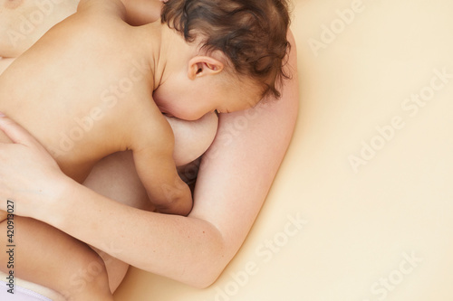 Naked baby sucking naked mother's breast photo