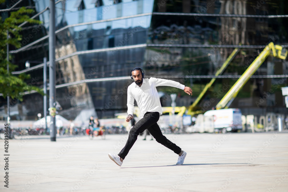 Man with headphones dancing in city Man with headphones dancing in city
