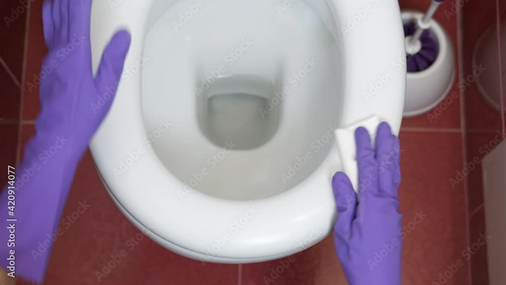Wash the toilet. A woman's hand in gloves washes the toilet seat. Stock ビデオ Adobe Stock