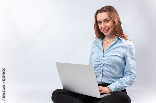 smiling businesswoman sits with laptop on her lap. isolated