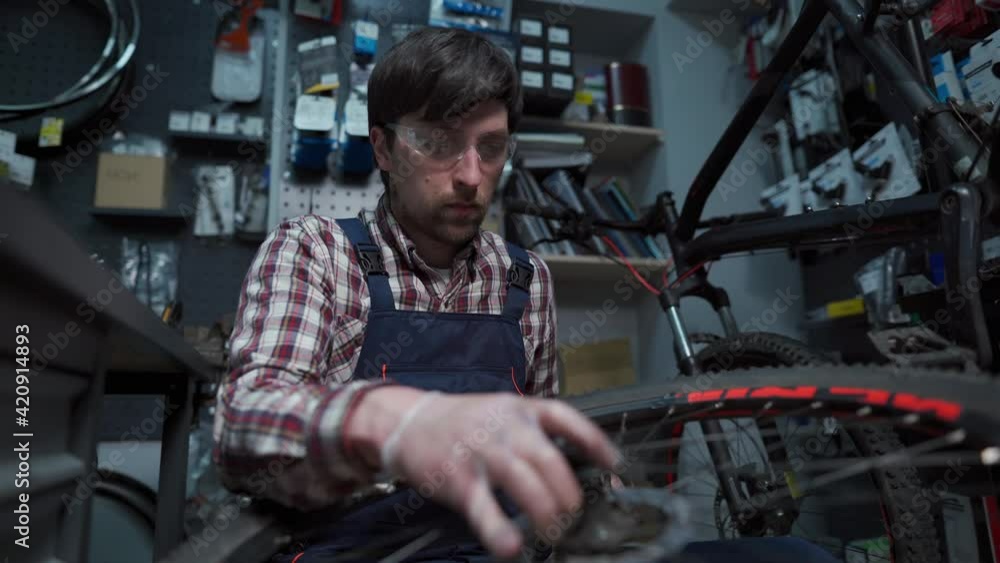 custom made wallpaper toronto digitalBike shop mechanic fixing bicycle wheel in workshop. Serviceman repair, maintenance cycle. Velocipede repairing bicycle in bike shop. Bicycle repair service concept. Environmentally friendly vehicles
