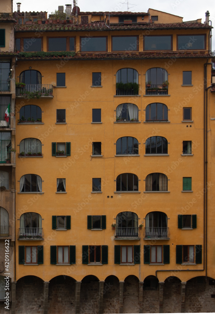 Edificio antiguo muy pintoresco color amarillo a orillas del río Arno en Florencia, Italia