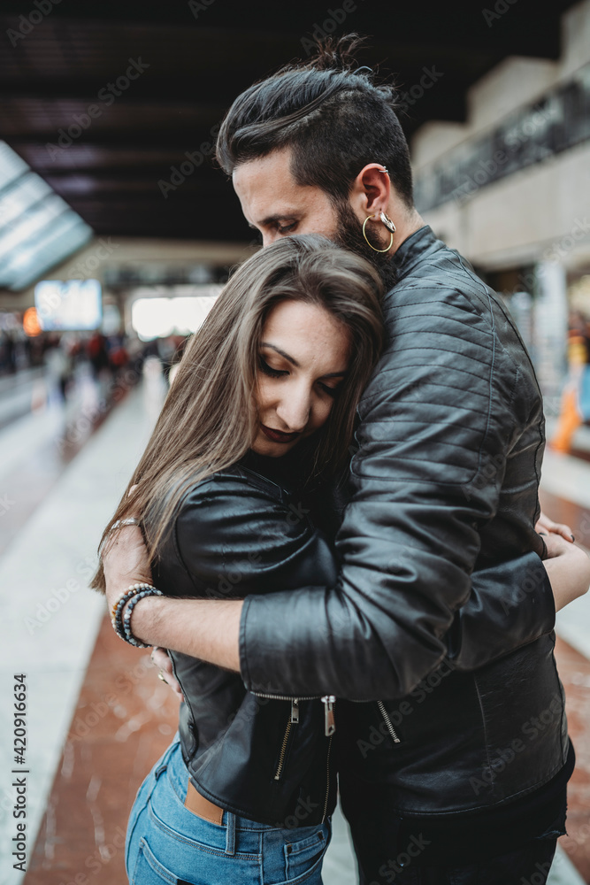 Couple hugging in station Couple hugging in station