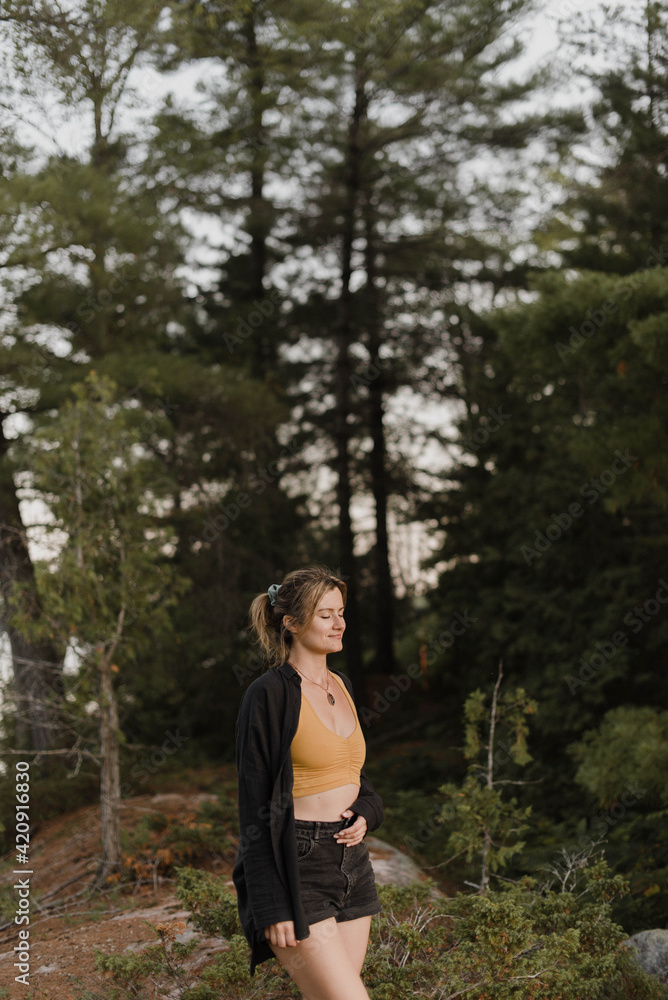 Woman relaxing with eyes closed in forest Woman relaxing with eyes closed in forest