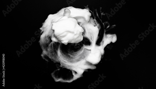 White soapy foam texture. Shampoo foam with bubbles.White facial foam creamy bubble soap sponge isolated on black background.