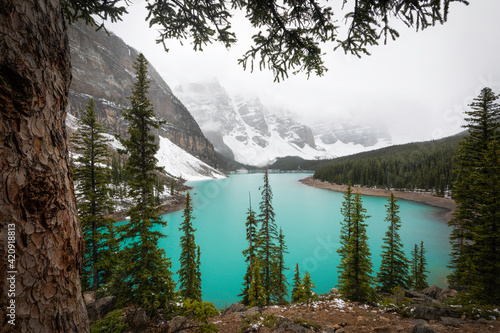 Iconic Moraine Lake in Banff National Park on a foggy, weather filled early Summer afternoon.