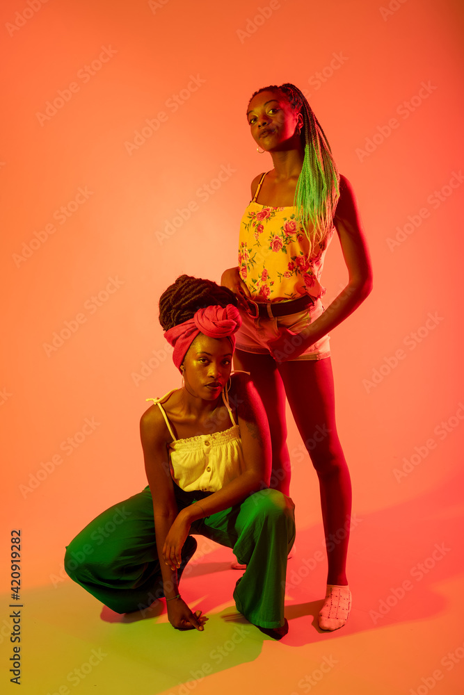 Friends posing against orange background Friends posing against orange background