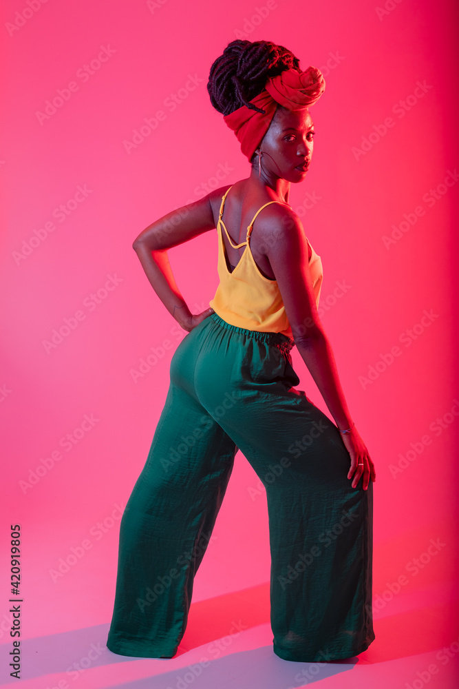 Woman with headscarf posing against pink background Woman with headscarf posing against pink background