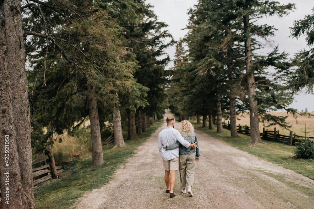 Young couple walking with hand around waist in countryside Young couple walking with hand around waist in countryside