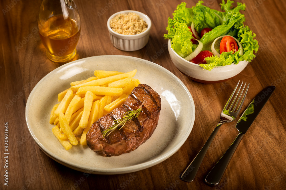 Grilled steak with french fries, brazilian farofa and salad. Grilled steak with french fries, brazilian farofa and salad.