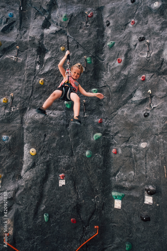 Young boy abseiling from a rock climbing wall in Bolzano, Lombardy, Italy. Young boy abseiling from a rock climbing wall in Bolzano, Lombardy, Italy.
