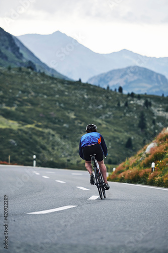 Fototapeta Naklejka Na Ścianę i Meble -  Male cyclist cycling on mountain road, Flüela Pass, Davos, Graubünden, Switzerland