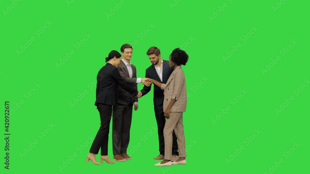 A business meeting, official meeting: partners meet, handshake and pose for a picture on a Green Screen, Chroma Key. A business meeting, official meeting: partners meet, handshake and pose for a picture on a Green Screen, Chroma Key.